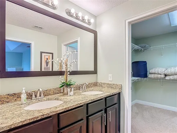 a bedroom with a bed and a flat tv screen on dresser