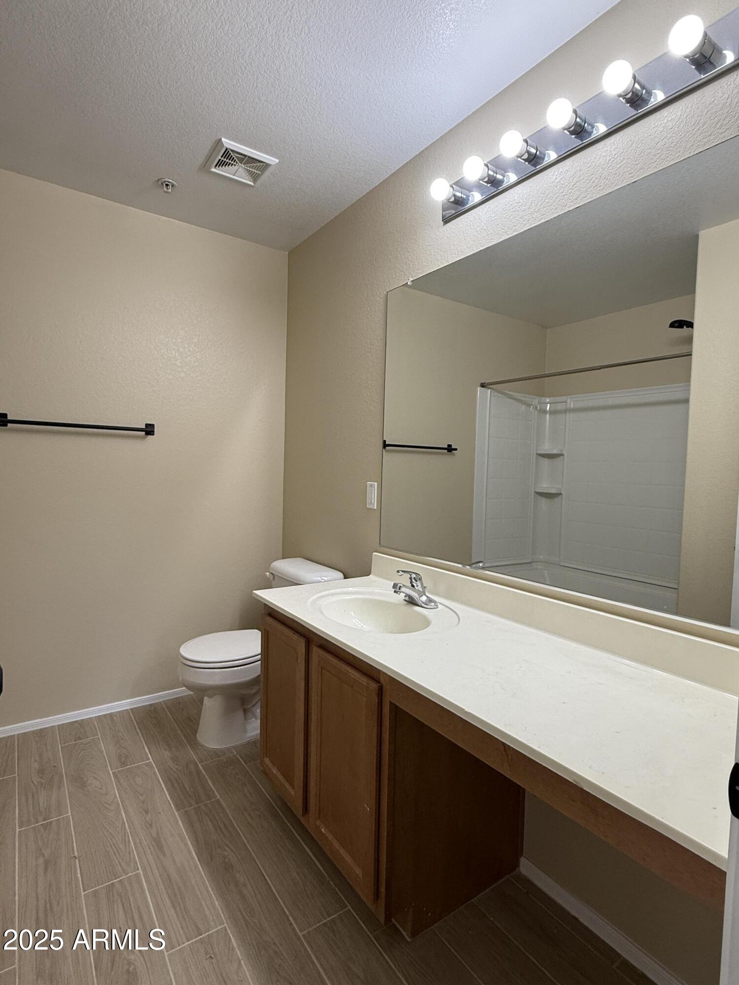 1265 South Aaron, Unit 277 Mesa, AZ 85209 - Photo 14 of 37 a bathroom with a sink a toilet a mirror and vanity