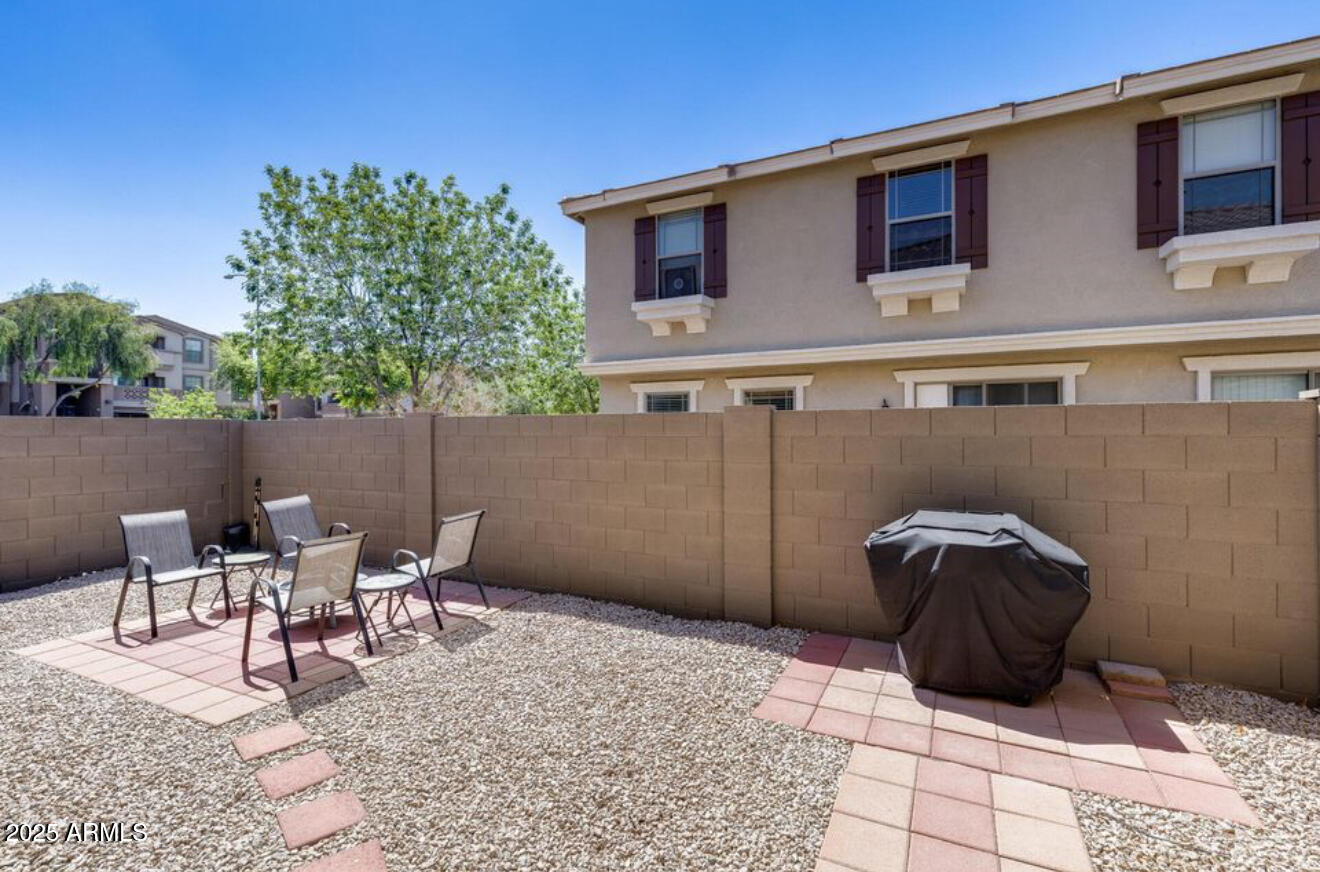 1265 South Aaron, Unit 277 Mesa, AZ 85209 - Photo 17 of 37 a view of a patio with table and chairs with wooden fence