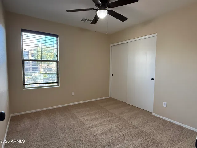 a view of empty room with wooden floor and ceiling fan