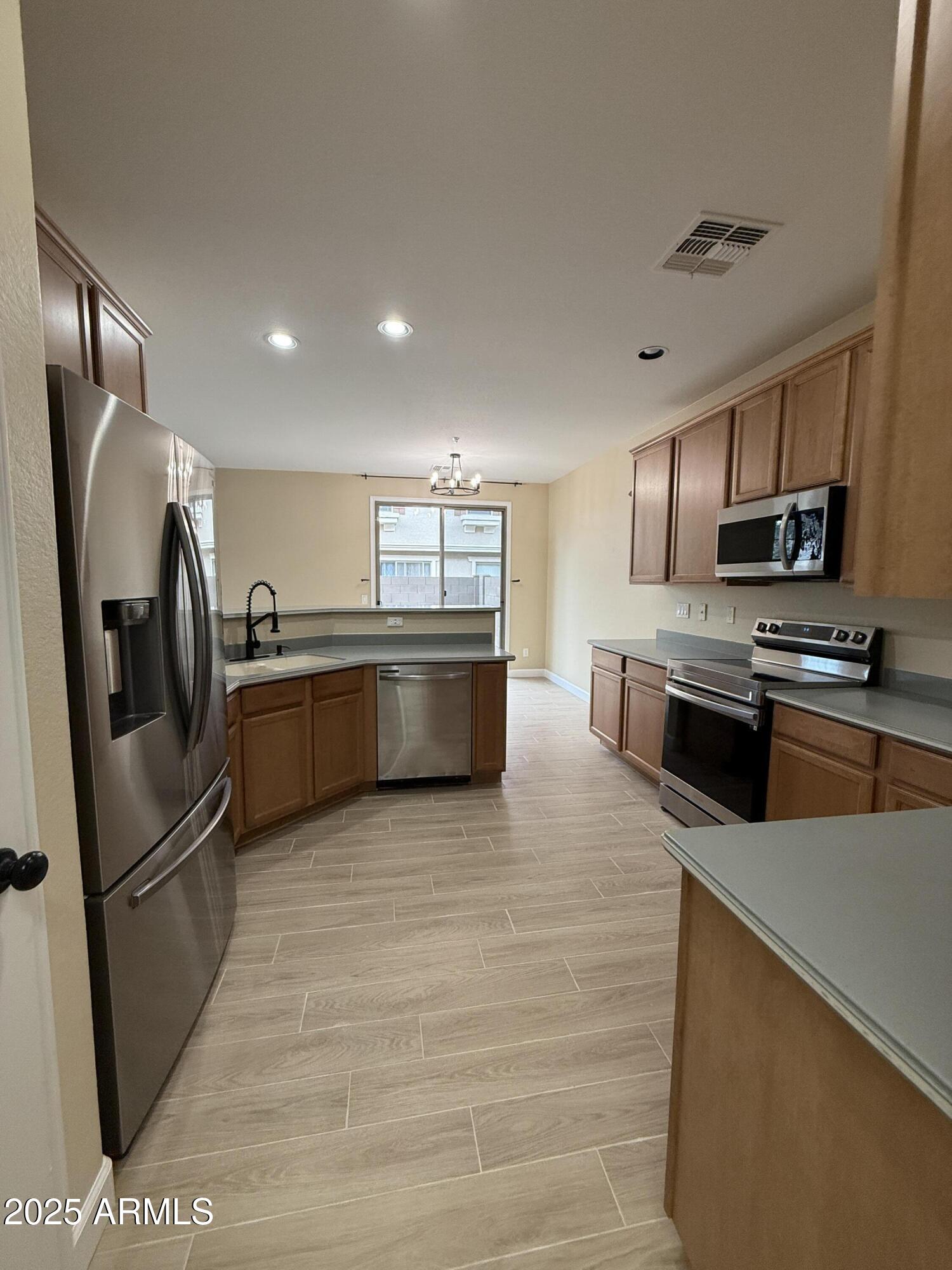 1265 South Aaron, Unit 277 Mesa, AZ 85209 - Photo 35 of 37 a kitchen with stainless steel appliances granite countertop a refrigerator sink and stove