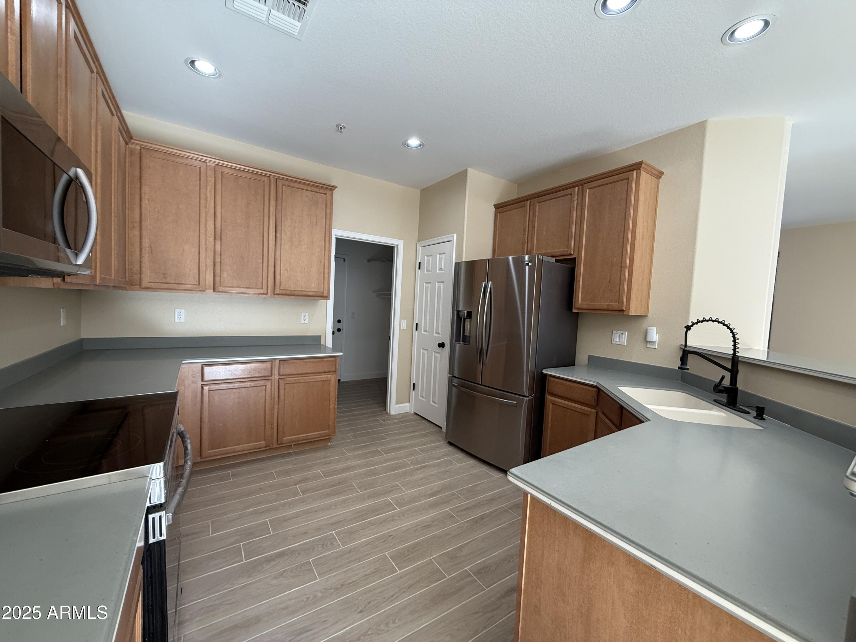 1265 South Aaron, Unit 277 Mesa, AZ 85209 - Photo 4 of 37 a kitchen with stainless steel appliances granite countertop a refrigerator and a stove top oven