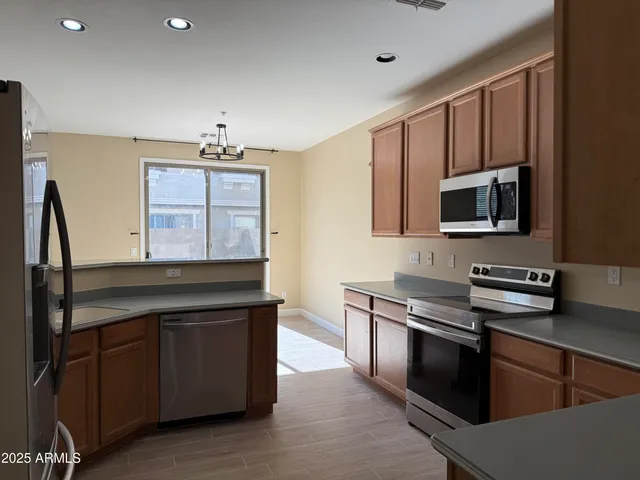 a kitchen with stainless steel appliances granite countertop a refrigerator and a stove top oven