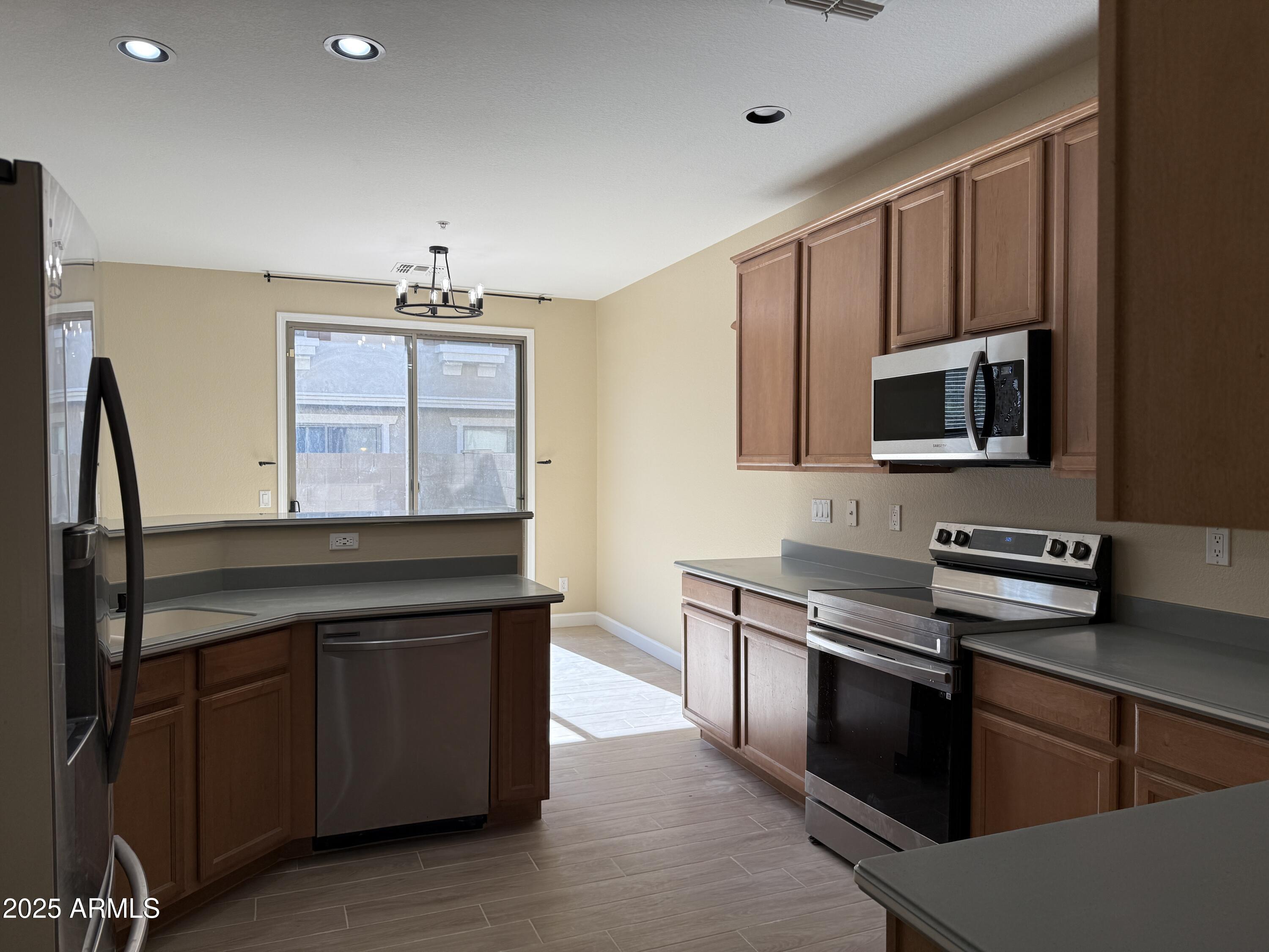 1265 South Aaron, Unit 277 Mesa, AZ 85209 - Photo 5 of 37 a kitchen with stainless steel appliances granite countertop a stove a sink and a microwave