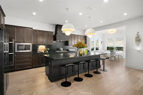 a kitchen with stainless steel appliances kitchen island granite countertop a sink counter and chairs