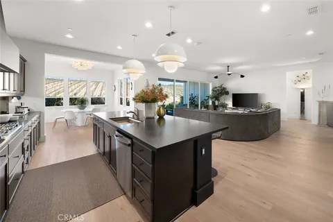 a kitchen with stainless steel appliances kitchen island granite countertop a stove a sink a dining table and chairs