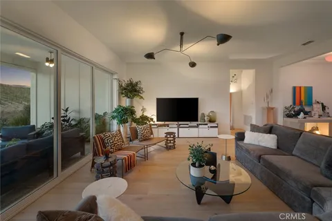 a living room with furniture a flat screen tv and a large window