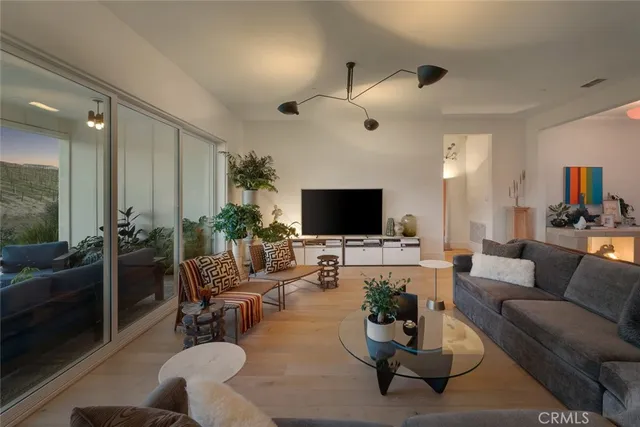 a living room with furniture a flat screen tv and a large window