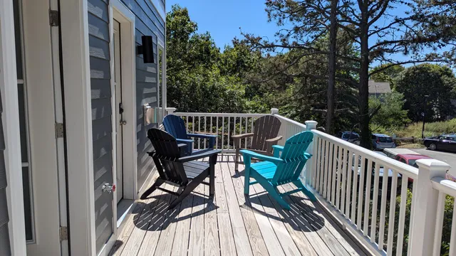 an empty room with wooden floor and a kitchen