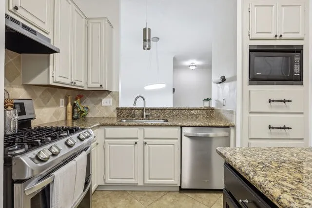 a kitchen with stainless steel appliances granite countertop a sink stove and cabinets