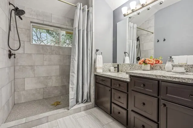 a bathroom with a double vanity sink and shower