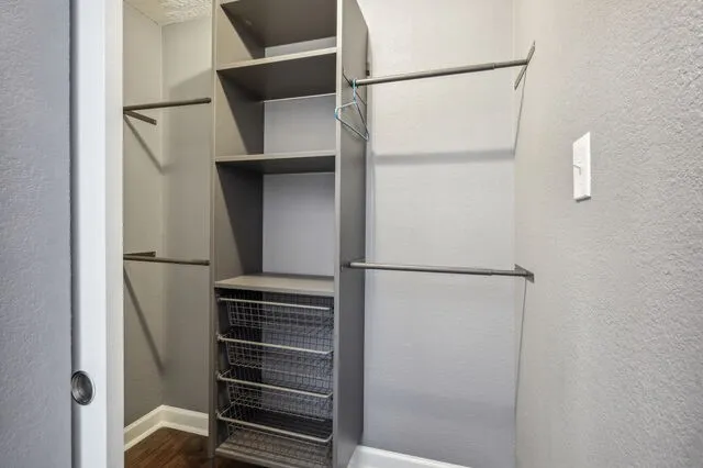 an empty room with wooden floor ceiling fan and windows