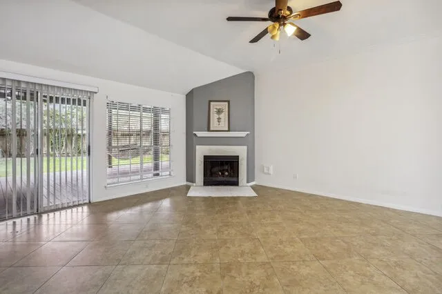 a view of an empty room with a fireplace and a window