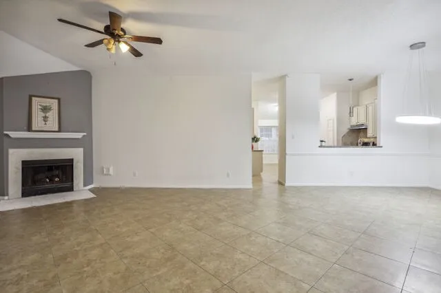 a view of a livingroom with a fireplace and a chandelier fan
