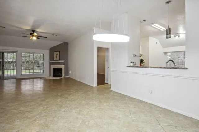 a view of an empty room with a fireplace and a window