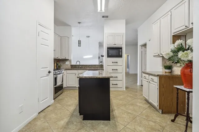 a large kitchen with cabinets and stainless steel appliances