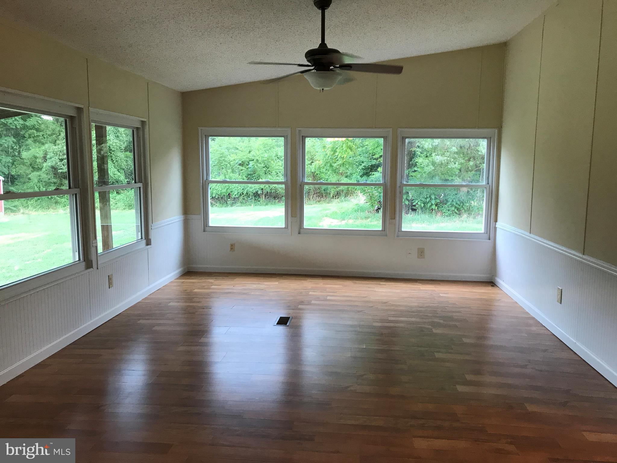 11641 Belfonte Road Bumpass, VA 23024 - Photo 13 of 23 a view of an empty room with wooden floor and a window
