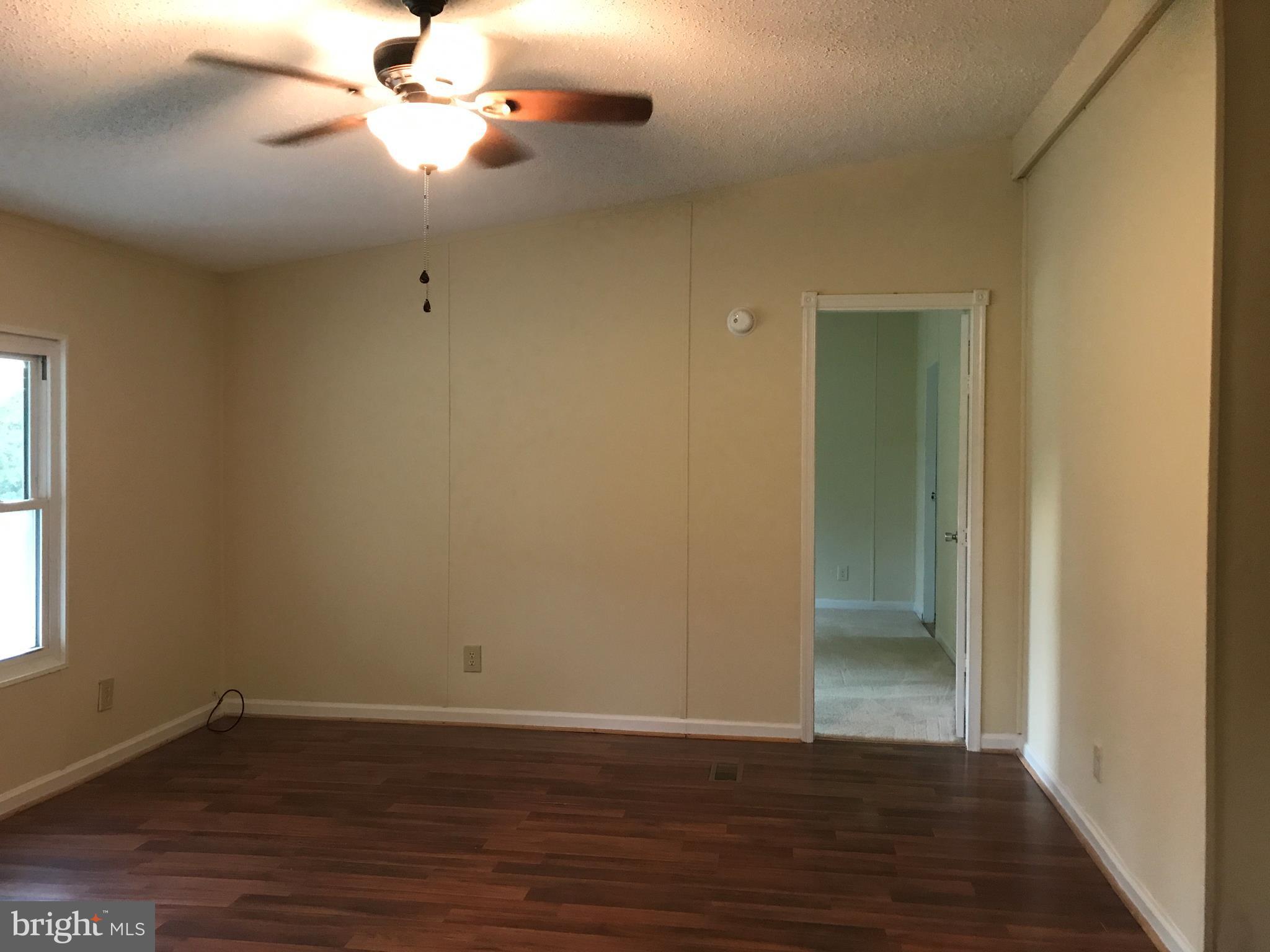 11641 Belfonte Road Bumpass, VA 23024 - Photo 17 of 23 an empty room with wooden floor and windows