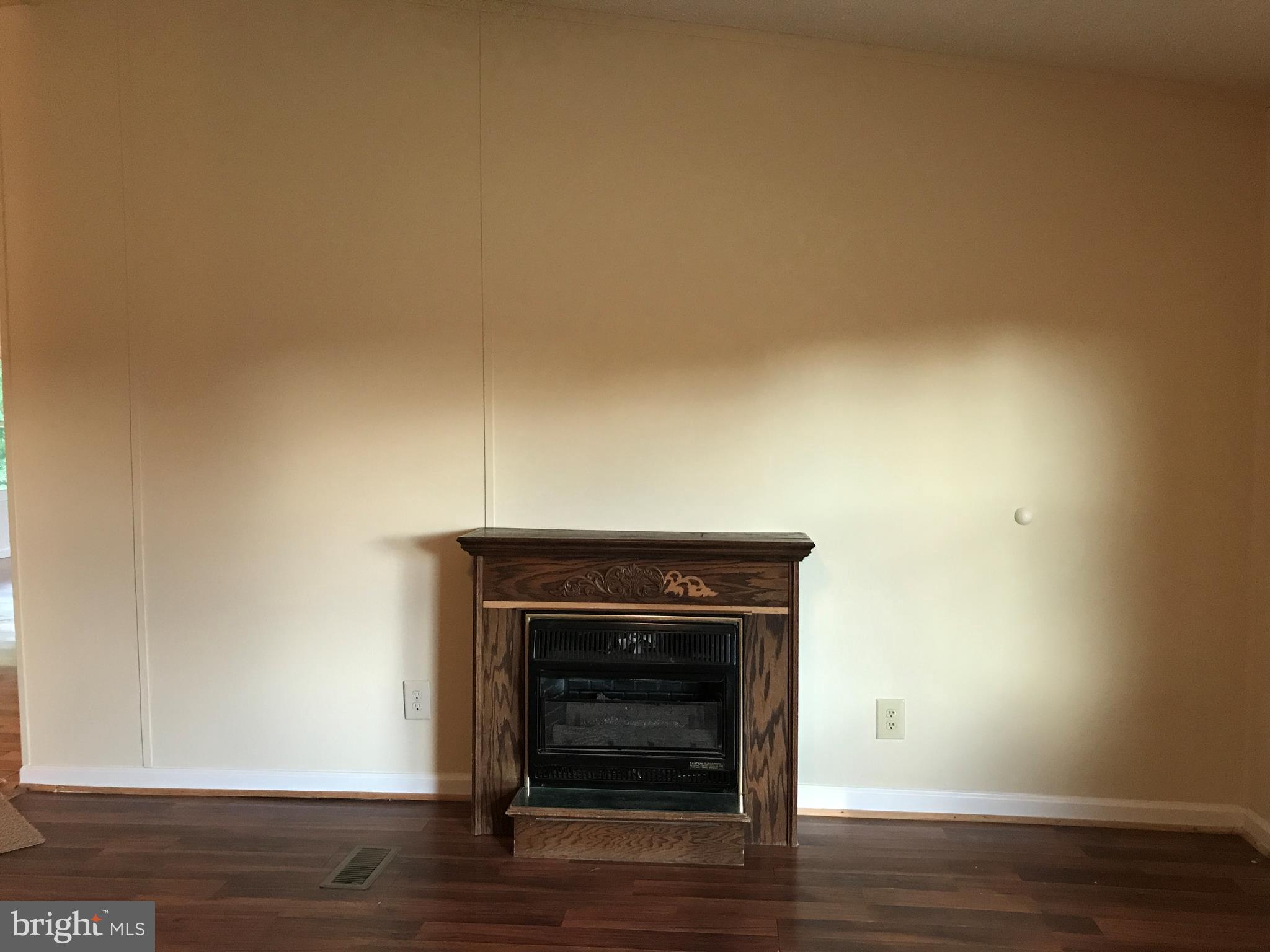 11641 Belfonte Road Bumpass, VA 23024 - Photo 23 of 23 a view of an empty room with wooden floor and a fireplace