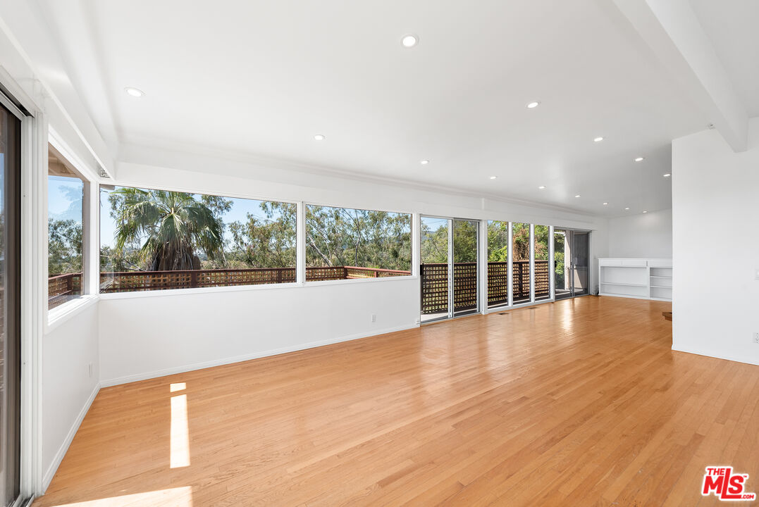 1211 North Kenter Avenue Los Angeles, CA 90049 - Photo 2 of 11 a view of an empty room with wooden floor and a window