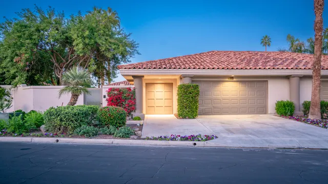 a front view of a house with a yard and potted plants