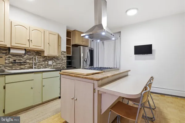 a kitchen with stainless steel appliances granite countertop a stove top oven a sink dishwasher and a refrigerator with wooden floor