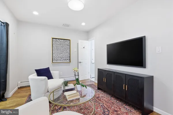 a living room with furniture and a wooden floor
