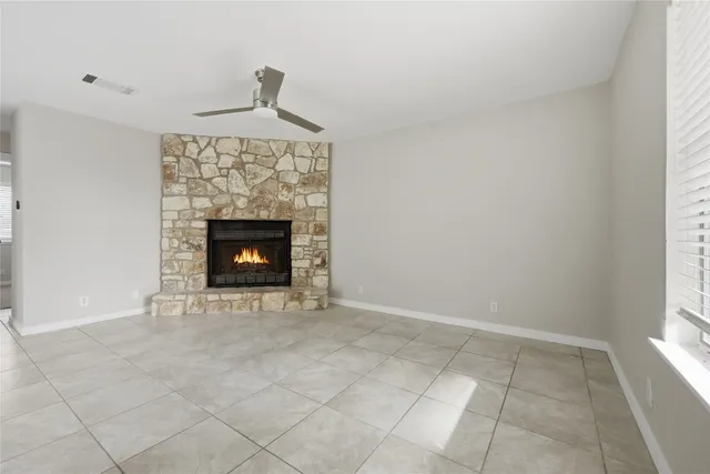 a room with a fireplace a rug and a window