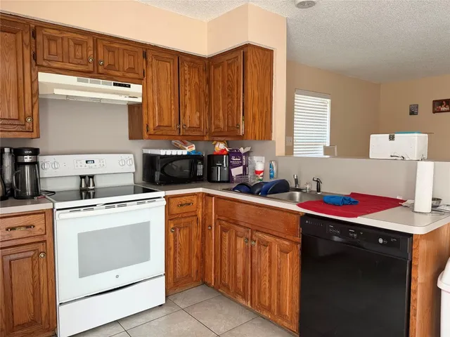 a kitchen with stainless steel appliances granite countertop a sink dishwasher stove and cabinets