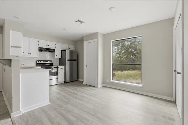 a kitchen with stainless steel appliances a refrigerator and a stove top oven