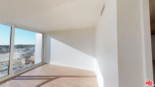 a view of a big room with wooden floor and windows