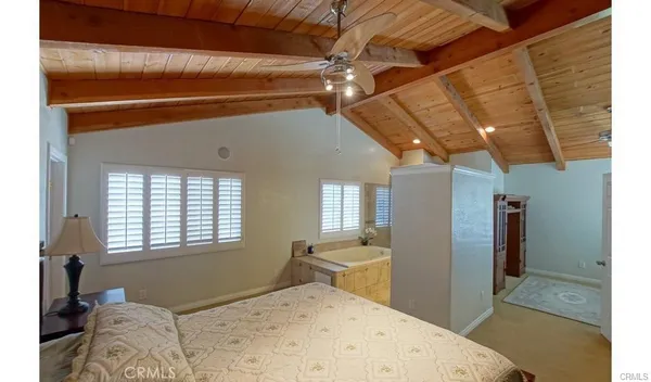 a bedroom with a bed and a dresser next to a window