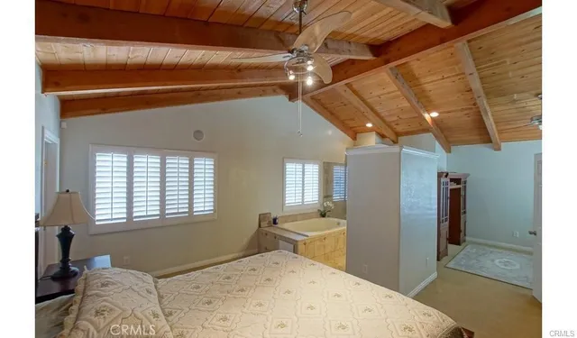 a bedroom with a bed and a dresser next to a window