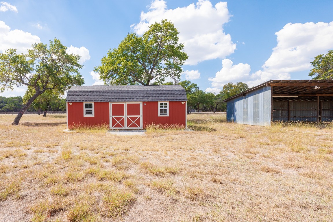 1301 Sandy Point Road Wimberley, TX 78676 - Photo 22 of 25 a view of a house with a yard and garage