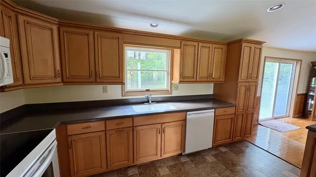 a kitchen with stainless steel appliances granite countertop sink stove top oven and cabinets