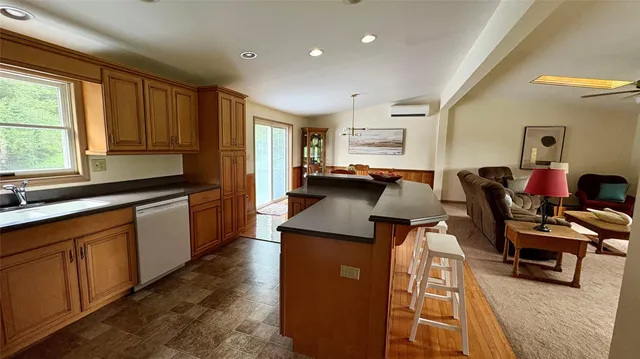 a kitchen with stainless steel appliances granite countertop a stove a refrigerator a dining table and chairs