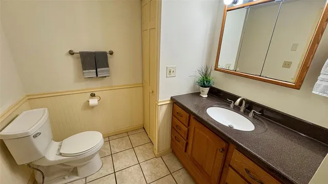 a bathroom with a granite countertop sink toilet a mirror and vanity