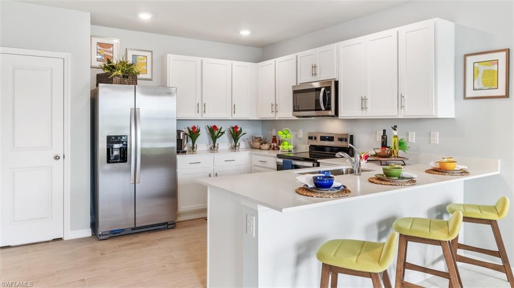 17613 Shade Tree Loop Punta Gorda, FL 33982 - Photo 5 of 27 a kitchen with stainless steel appliances granite countertop a refrigerator and microwave