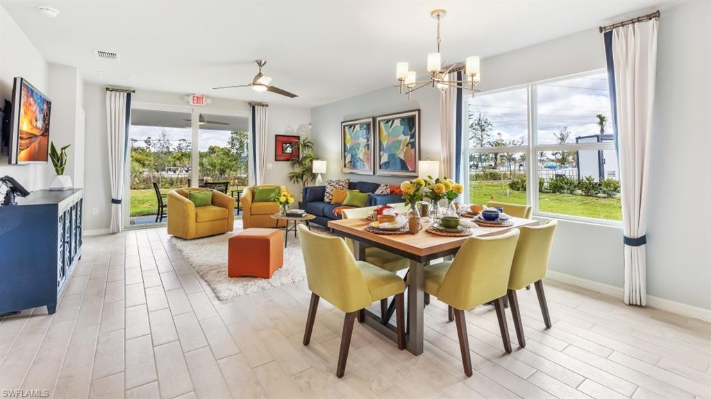 17613 Shade Tree Loop Punta Gorda, FL 33982 - Photo 7 of 27 a dining room with furniture a chandelier and wooden floor