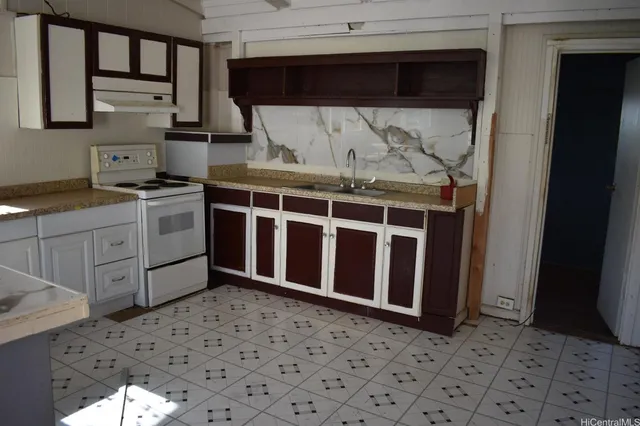a kitchen with a sink a stove and cabinets