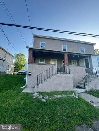 a view of house with backyard and outdoor seating