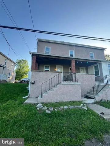 a view of house with backyard and outdoor seating