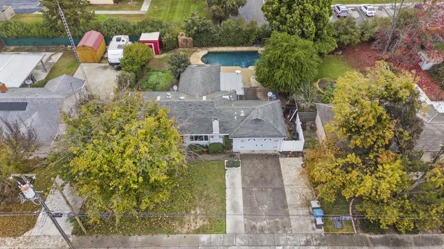 an aerial view of residential houses with outdoor space and trees
