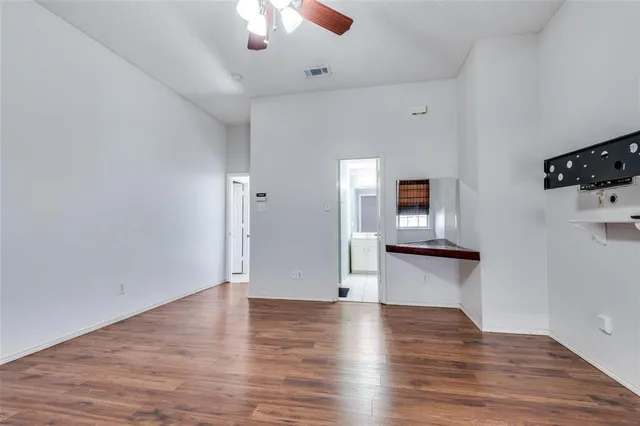 a view of empty room with wooden floor and window