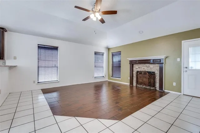 a view of an empty room with window and fireplace