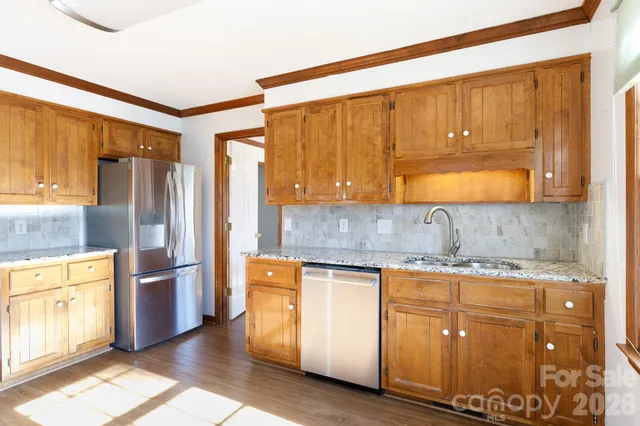 a kitchen with stainless steel appliances granite countertop a refrigerator and a stove