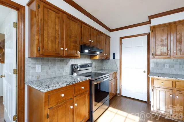 a kitchen with stainless steel appliances granite countertop a stove a sink and a microwave