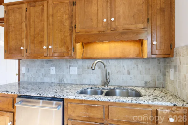 a kitchen with granite countertop cabinets and white appliances