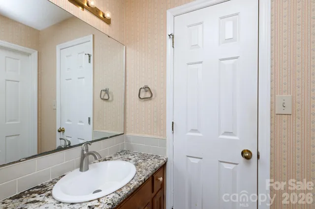 a bathroom with a granite countertop sink a toilet and shower