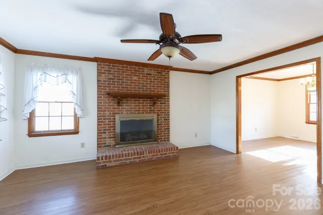 an empty room with windows and fireplace